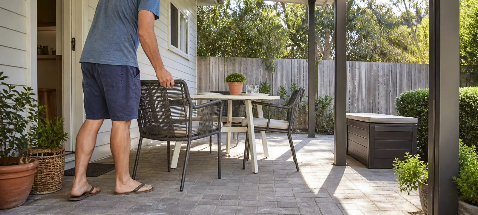An Australian homeowner moving a patio chair to check the clear path around an outdoor table