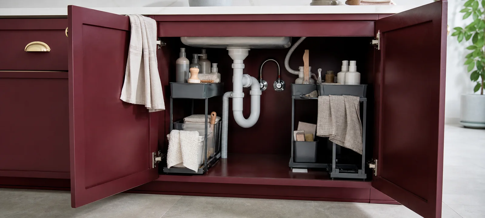 A warm kitchen with tidy under-sink storage and practical cleaning supplies