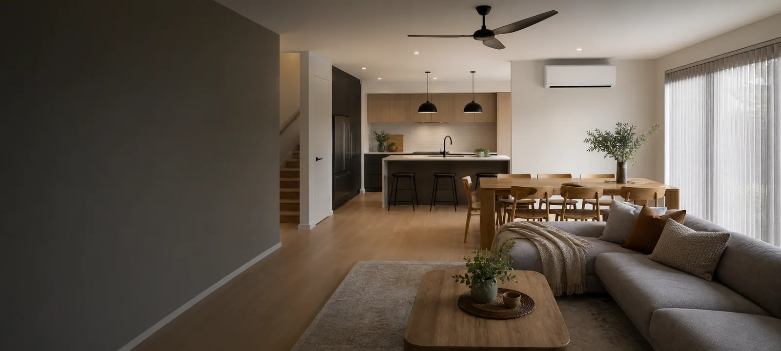 An open-plan Australian kitchen, dining and living area heated by a wall-mounted reverse-cycle air conditioner